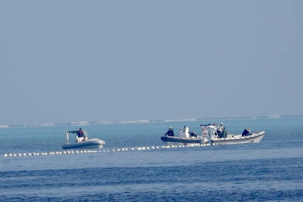 Chinese coastguard boats patrol next to a floating barrier at Scarborough Shoal in the disputed South China Sea. Photo: Handout via EPA-EFE