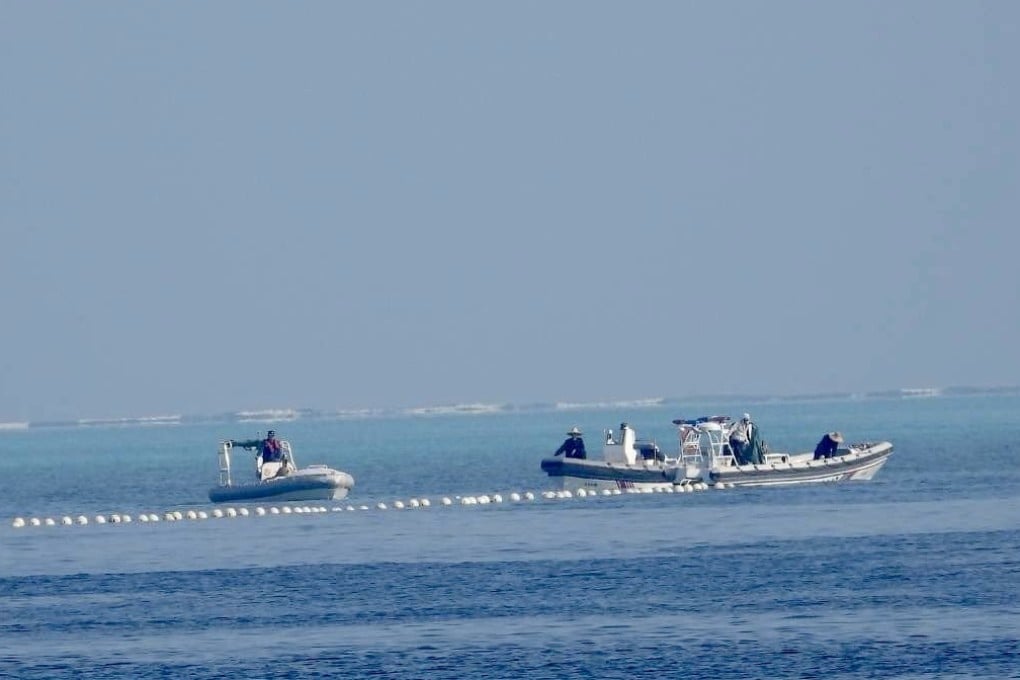 Chinese coastguard boats patrol next to a floating barrier at Scarborough Shoal in the disputed South China Sea. Photo: Handout via EPA-EFE