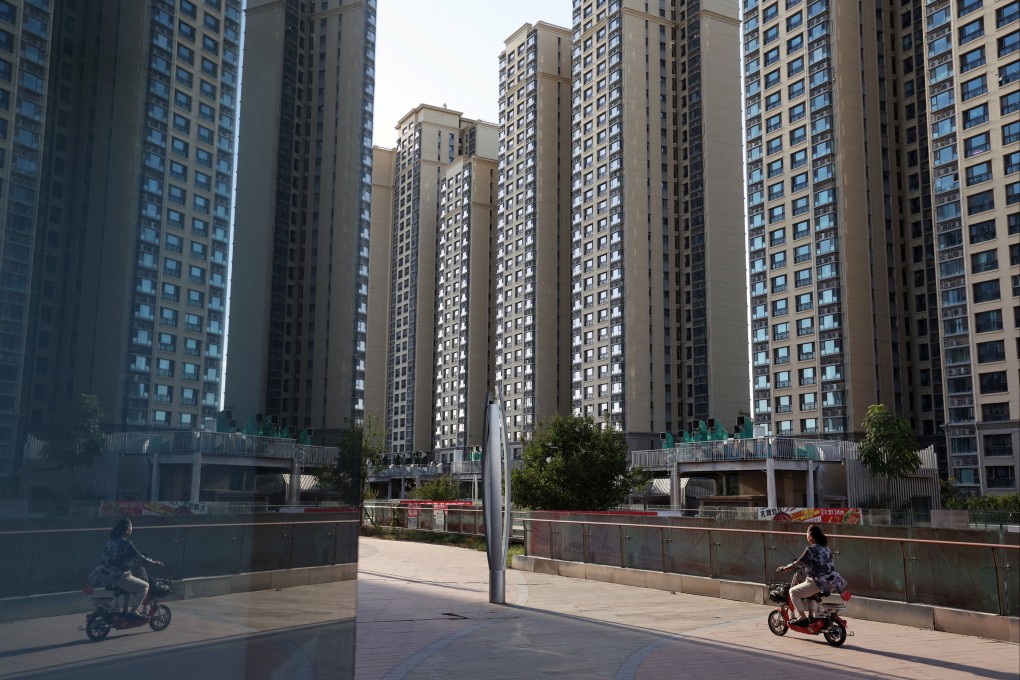 A woman rides past residential buildings at an Evergrande residential complex in Beijing. Photo: Reuters