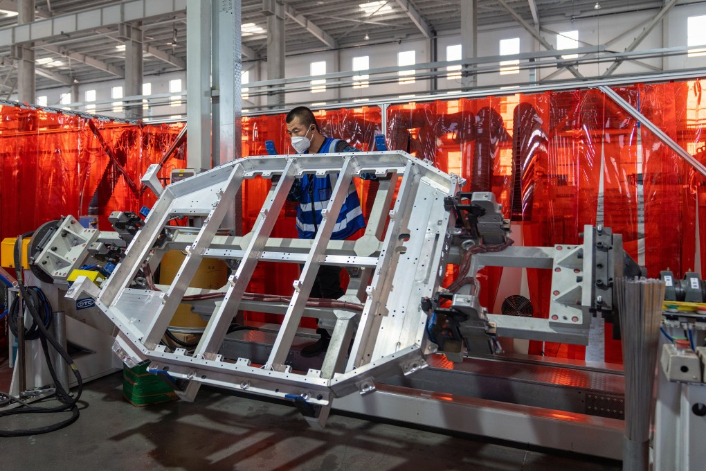 Workers produce electric vehicle power lithium battery housings at a workshop in Hefei, Anhui province, China. Photo: Getty Images