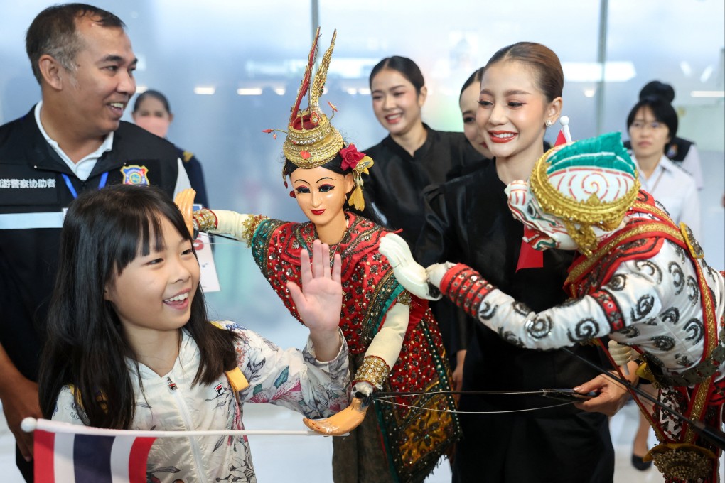A Chinese tourist is welcomed by Thai traditional puppets at Suvarnabhumi airport in Bangkok on September 25. Photo: Reuters