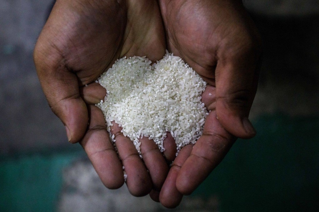 A worker shows grains of imported Indian white rice during the polishing process at a warehouse in Selangor. Malaysia says it will limit retail purchases and boost enforcement to prevent locally produced rice being sold as the more expensive imported grain, as the fallout from India’s export curbs continue to upend the market. Photo: Bloomberg