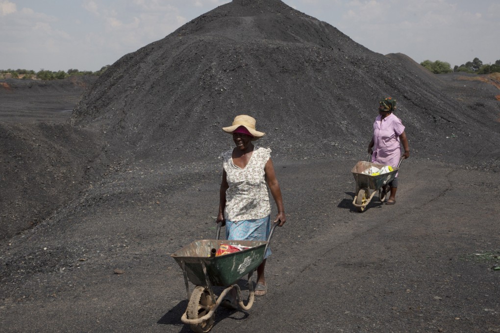 Women from the Masakhane township are seen on a coal mine dump at the coal-powered Duvha power station, near Emalahleni, east of Johannesburg, on November 17, 2022.  Living in the shadow of one of South Africa’s largest coal-fired power stations, locals fear job losses if the facility is closed as the country moves to cleaner energy. Photo: AP