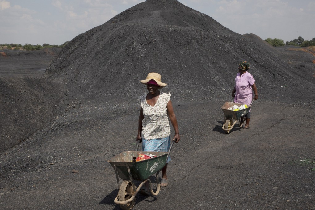Women from the Masakhane township are seen on a coal mine dump at the coal-powered Duvha power station, near Emalahleni, east of Johannesburg, on November 17, 2022. Living in the shadow of one of South Africa’s largest coal-fired power stations, locals fear job losses if the facility is closed as the country moves to cleaner energy. Photo: AP