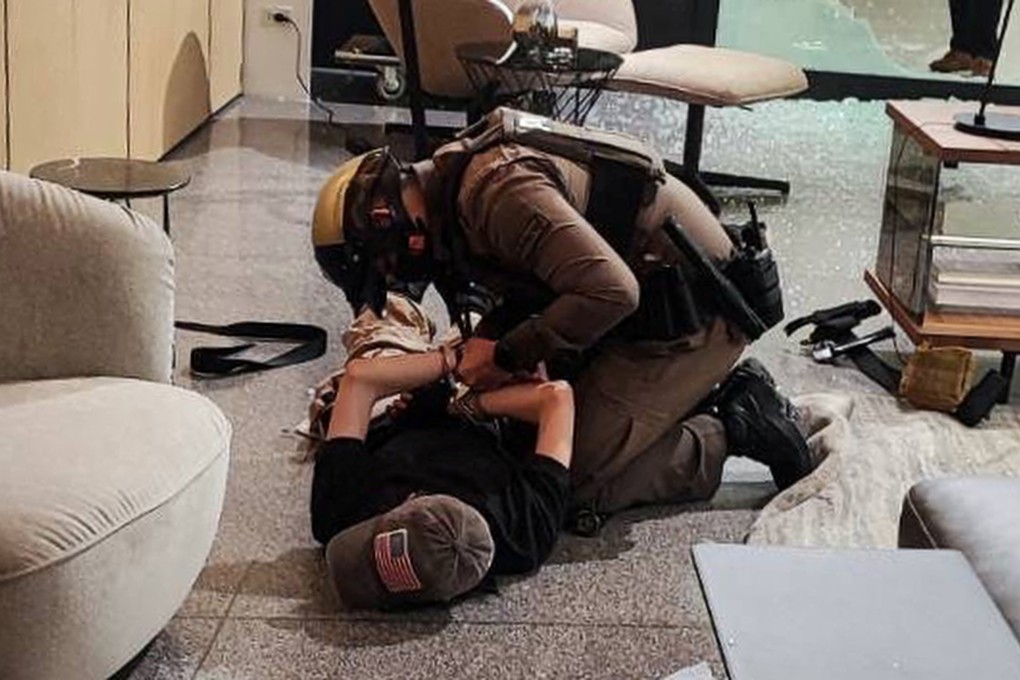 A suspect is detained following shots fired at the luxury Siam Paragon shopping centre. Photo: Reuters
