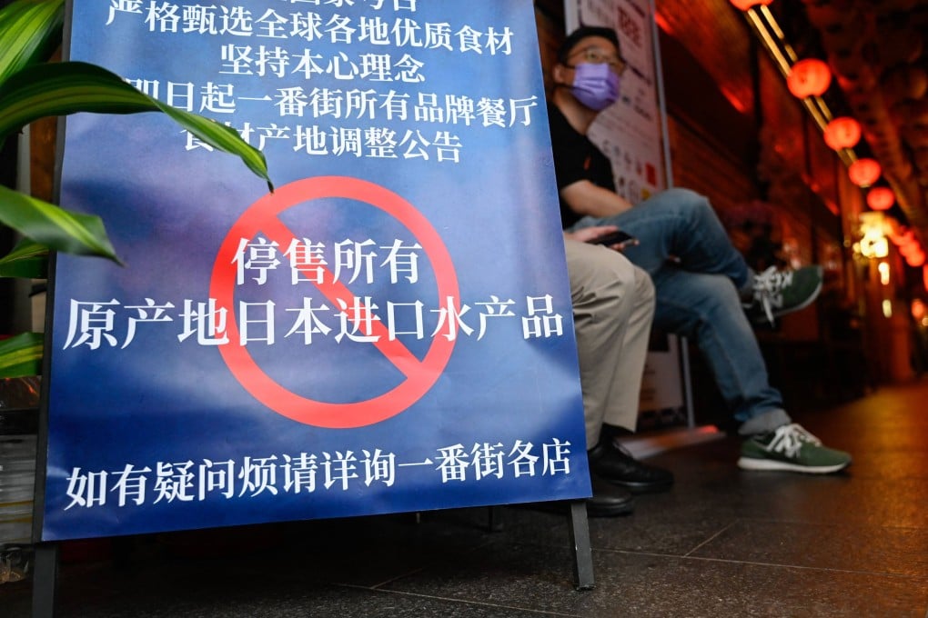 People in Beijing at an area of Japanese restaurants where there is a sign reading “Suspend the sale of all fish products imported from Japan”. There are already many issues that rile China when it comes to Japan. Photo: AFP