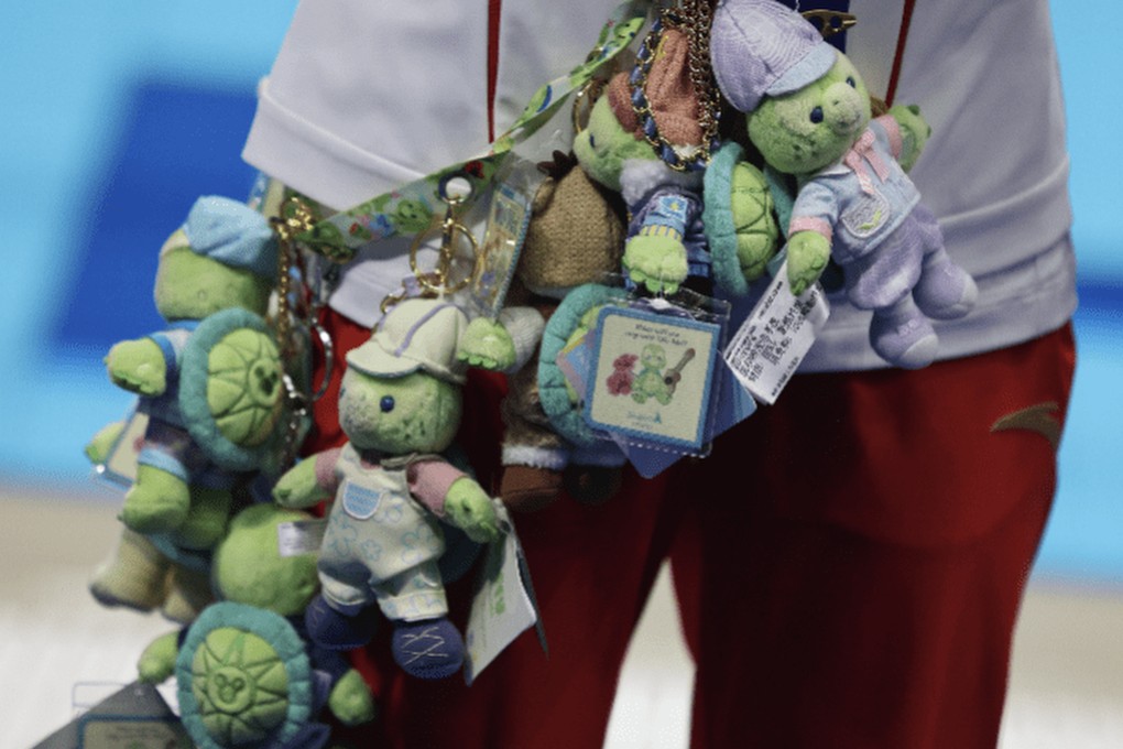 Teen diving sensation Quan Hongchan won gold for China on Tuesday, and more hearts by regifting a turtle toy thrown from a fan to her coach. Photo: Weibo