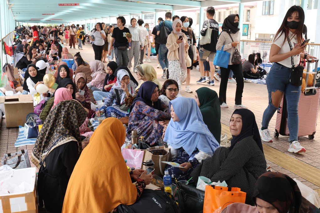 Domestic workers on a footbridge during their day off in Mong Kok, Hong Kong. MeHeal, a free counselling service set up by a Hong Kong charity, provides free mental health support to those who fear losing their jobs if employers see them as vulnerable. Photo: Edmond So
