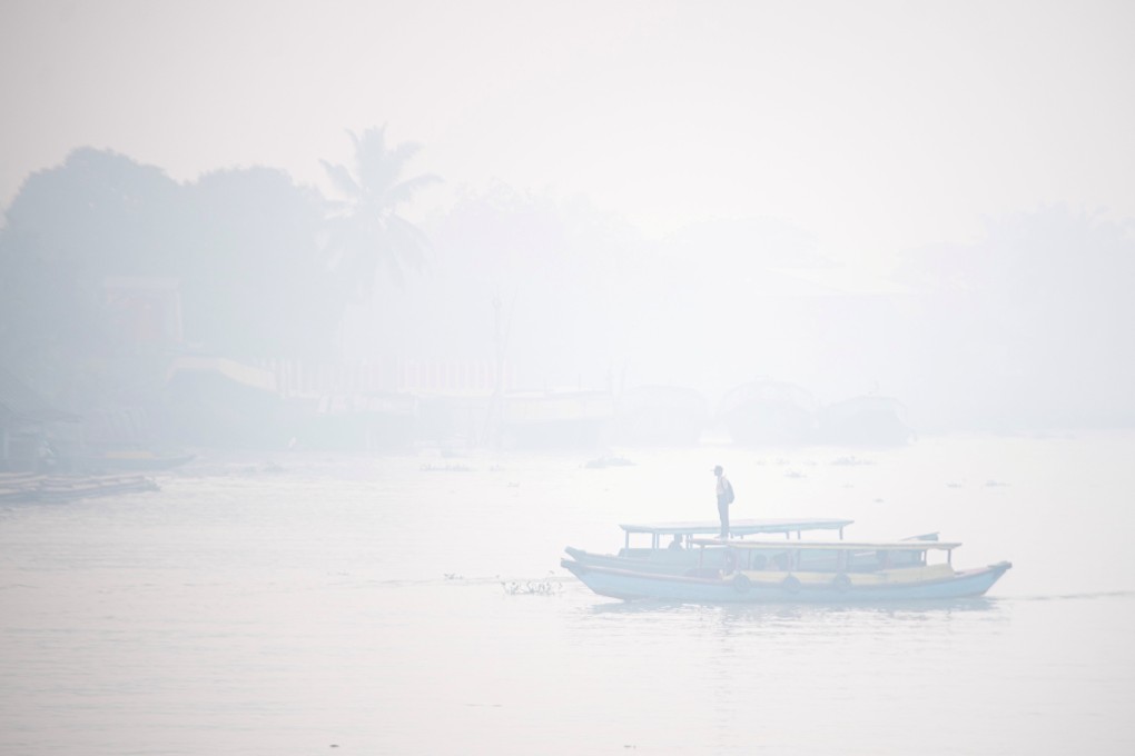Students ride a wooden boat through the smog-covered Ogan river in Palembang, Indonesia’s South Sumatra province, on September 30. Photo: Antara Foto/Reuters