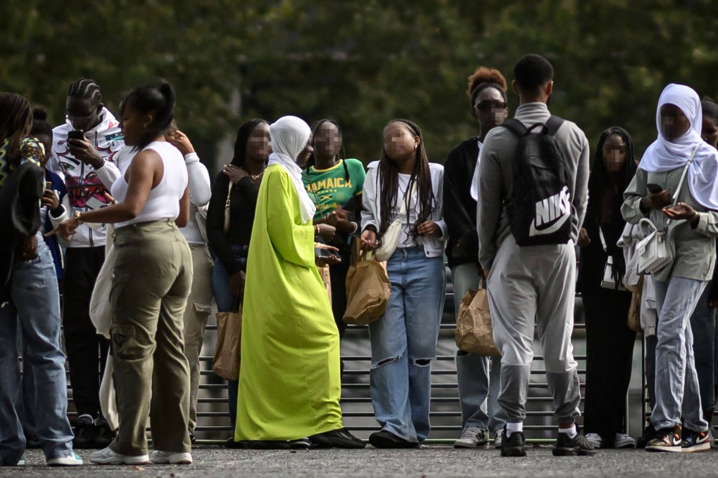 A young woman wearing an Abaya speaks with others on a street in Nantes, western France. Many critics argue that the abaya is a cultural garment, not a religious one. Photo: AFP