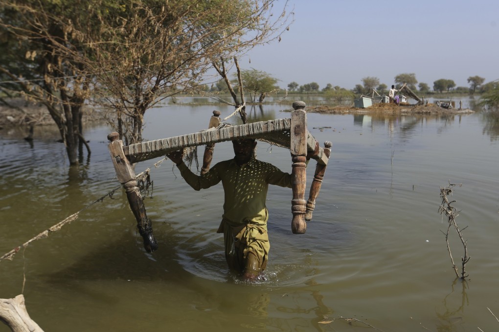 Villagers retrieve belongings in Sohbat Pur, a flood-hit district of Baluchistan province in Pakistan, on October 25, 2022. The rich world’s inaction on climate change is exacerbating environmental damage and social inequality in the developing world. Photo: AP