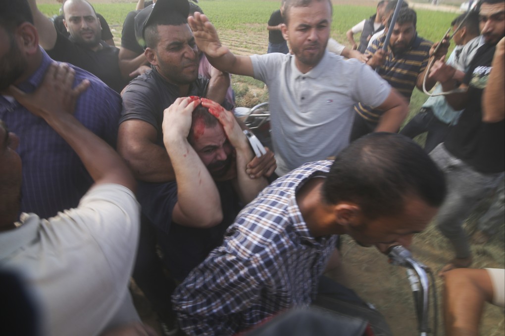 Palestinians take a captured Israeli civilian, centre, from Kibbutz Kfar Azza into the Gaza Strip on Saturday. Photo: AP