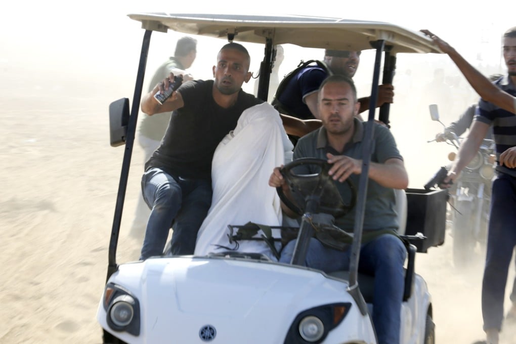 Palestinians transport a captured Israeli civilian from Kibbutz Kfar Azza into the Gaza Strip. Photo: AP