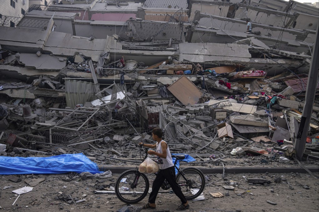 A Palestinian child walks by the rubble of a building in Gaza City after it was hit by an Israeli air strike. Photo: AP