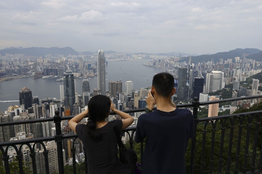 Tourists take photographs of the Hong Kong skyline from the Peak on July 27. Photo: Dickson Lee