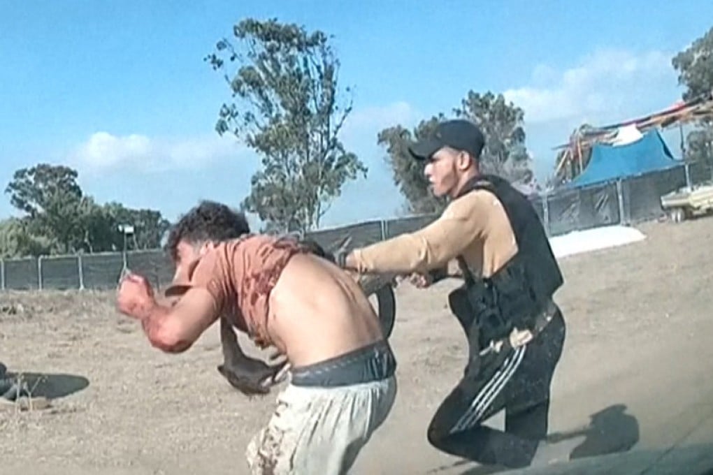 A man holding a weapon grabs another man during an attack by Hamas militants at the music festival. Photo: South First Responders via AP