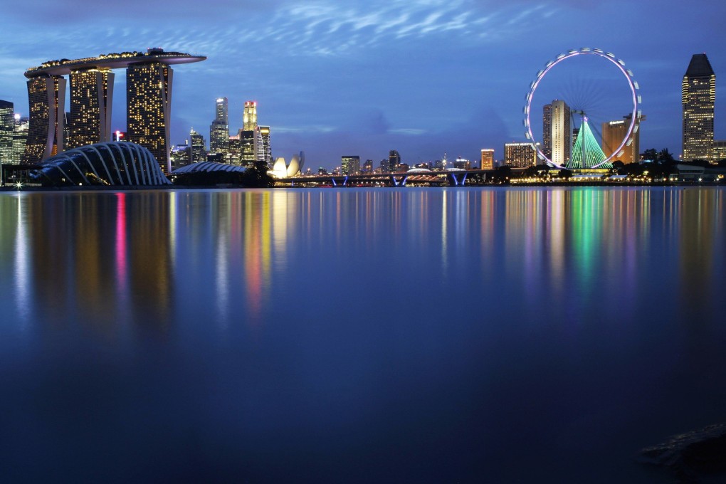 Lights of Singapore’s skyline and Marina Bay are reflected in the waters of the Marina Barrage. Photo: Reuters