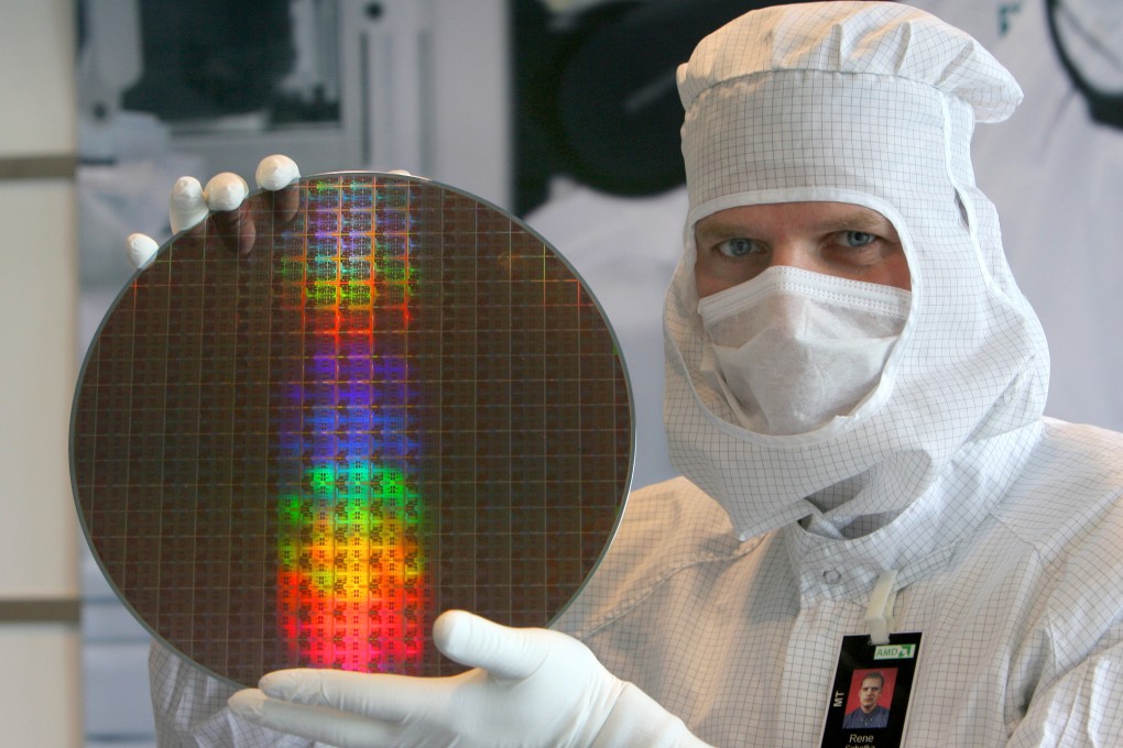 An employee holds a wafer at a German facility of US semiconductor manufacturer Advanced Micro Devices. Photo: dpa