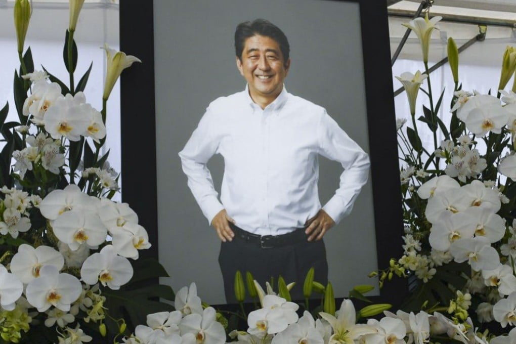 A photograph of former Japanese prime minister Shinzo Abe stands at a makeshift memorial at Zojoji temple in Tokyo, Japan, on July 12, 2022. His alleged assassin says he was really taking aim at the Unification Church, a powerful cult that has wielded signification influence in Japan for decades. Photo: Bloomberg
