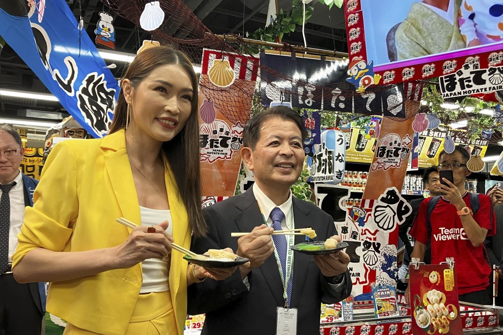 Japanese Agriculture Minister Ichiro Miyashita and Malaysian celebrity Amber Chia promote Japanese scallops to shoppers at a Don Don Donki outlet in Kuala Lumpur on October 4. Photo: AP