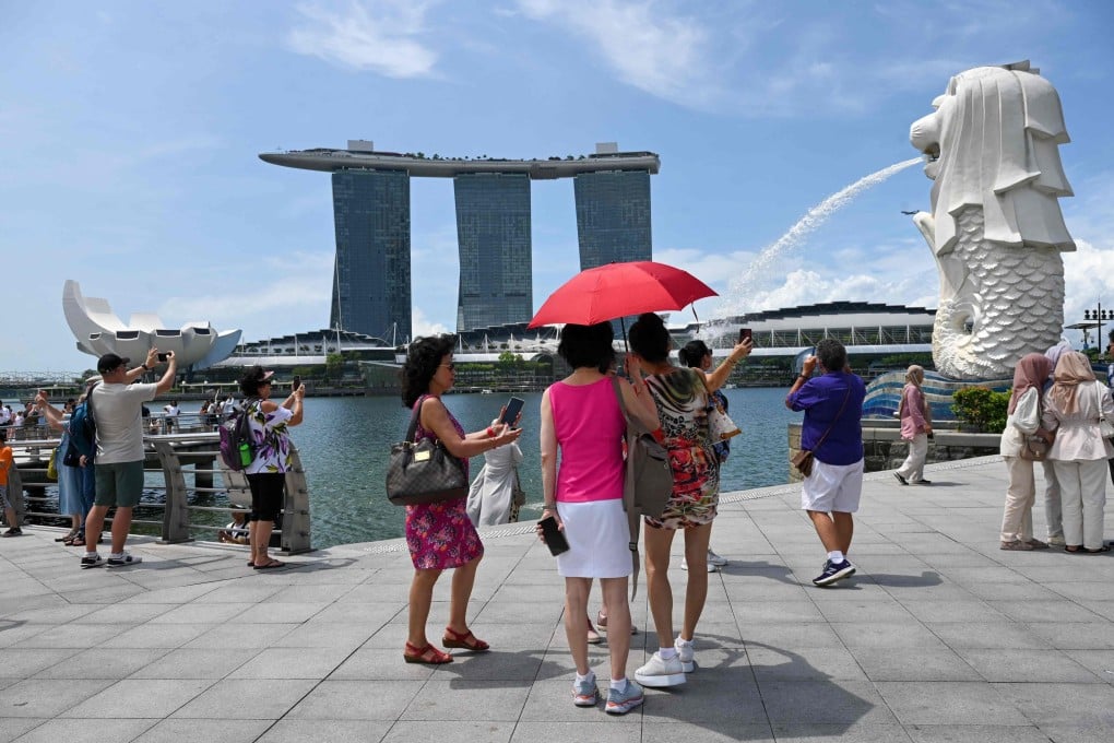 People take pictures next to the Merlion Statue at Marina Bay in Singapore. The city state reported a faster than expected GDP growth on Friday. Photo: AFP