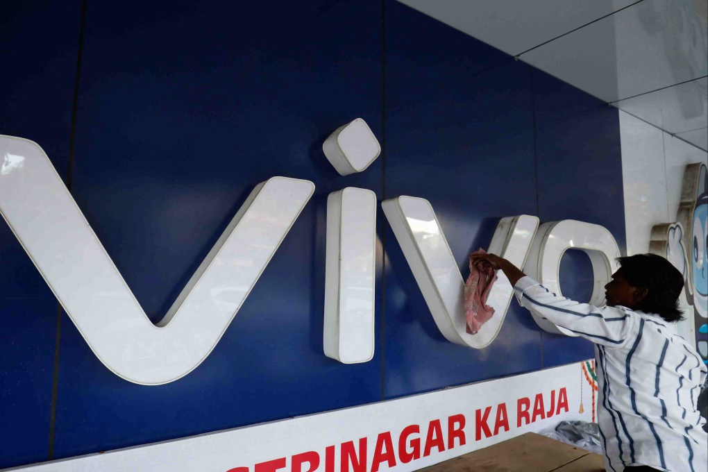 A man cleans the logo of Chinese smartphone company Vivo outside a store in Ahmedabad, India, on October 10. Officially, India is open to Chinese business. But the government has used various measures to make Chinese firms’ lives in India difficult or impossible. Photo: Reuters