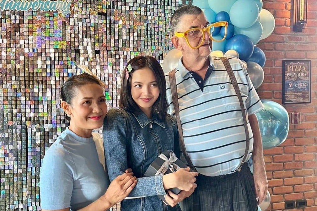 Lisa from Blackpink holds a TAG Heuer gift box as she poses with her mother and father on the latter’s birthday, prompting speculation the gift is from the watch brand’s chief executive, Frédéric Arnault - and fresh evidence he and the singer are dating. Photo: Twitter/@blckpinkpic