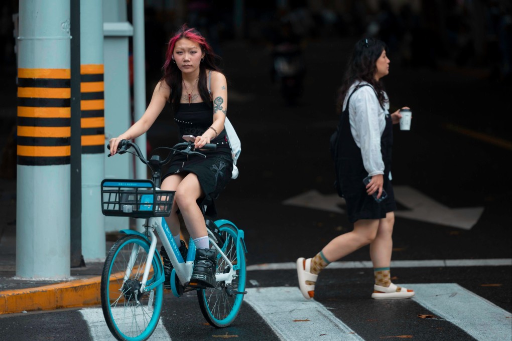 A young woman rides a bicycle in Shanghai on September 14. Already grappling with high youth unemployment amid a surplus of university graduates, China should carefully consider the impact of its localisation policies. Photo: EPA-EFE