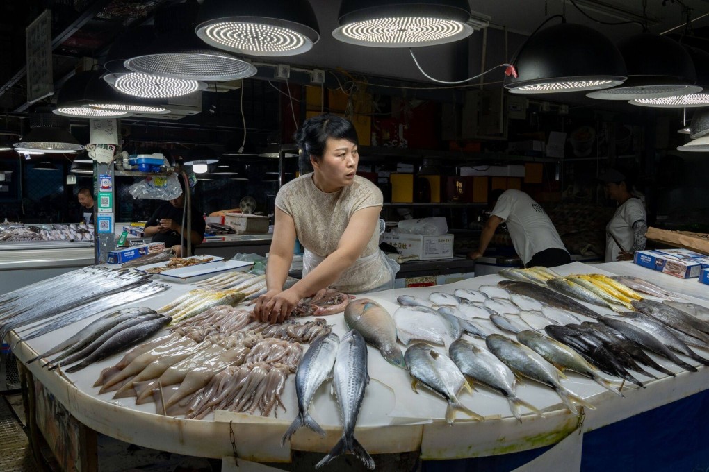 A vendor arranges seafood at her stall at a seafood market in Beijing. China’s erratic economic shifts are leaving small businesses in a difficult position. Photo: Bloomberg