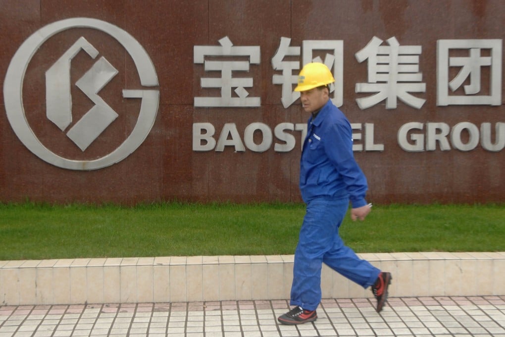 A labourer walks past the gate of the headquarters of Baosteel Group Corp. in Shanghai. Photo: Reuters