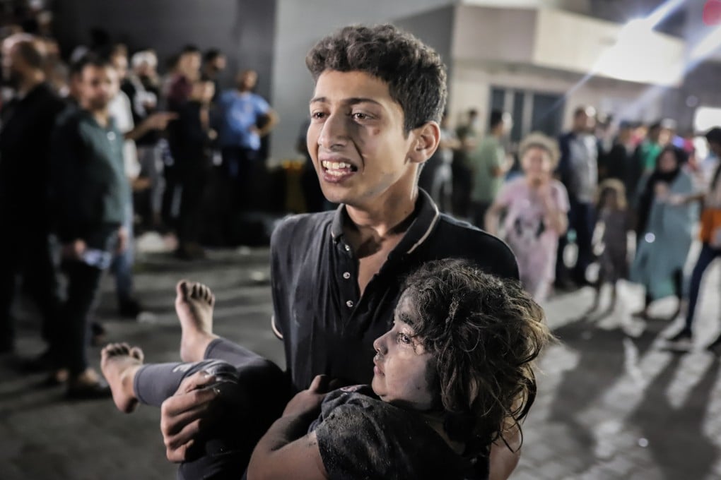 A Palestinian young man carries a child injured in a shelling on the Ahli Arab hospital in Gaza City. The lack of water and food in Gaza is inevitably affecting the young more immediately and more severely than adults. Photo: dpa
