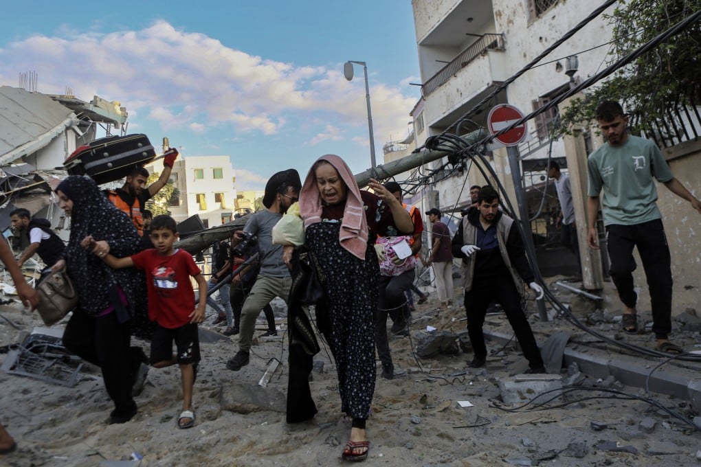 Palestinian families rush out of their homes after Israeli airstrikes targetted their neighbourhood in Gaza City on October 17, 2023. Photo: AP
