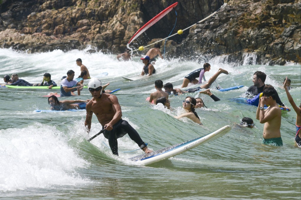 People enjoy the sun and surf at Big Wave Bay, Hong Kong, on October 9, 2022. There has been an explosion in the use of water sports equipment such as surfboards, canoes, stand-up paddle boards, and sailing and rowing boats. Photo: Antony Dickson