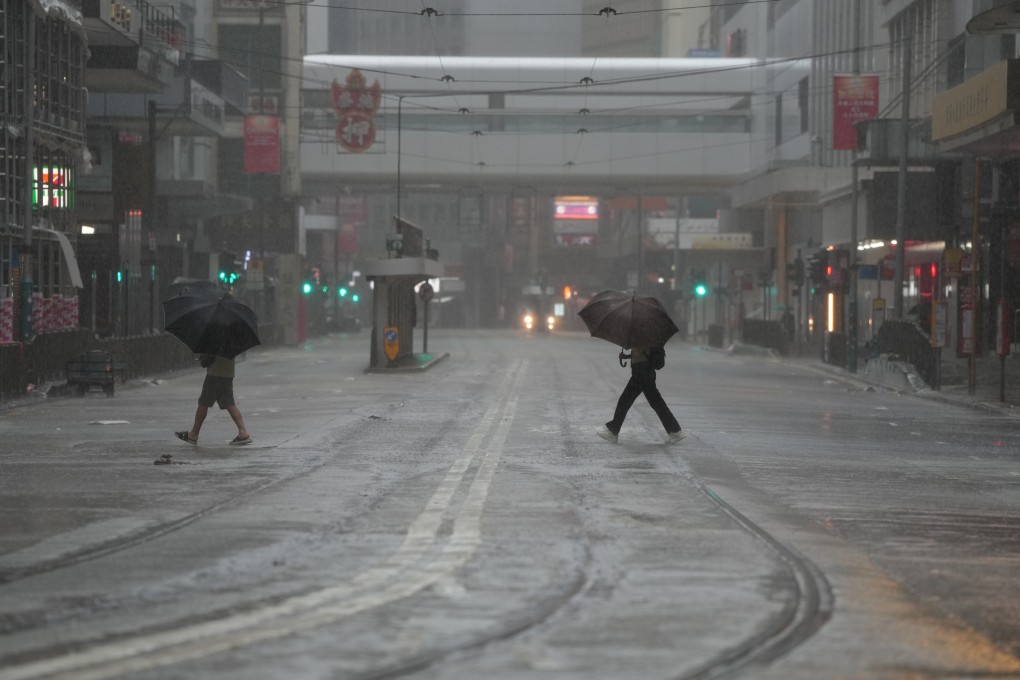 People cross a deserted street in Central, Hong Kong, after the Observatory raised the typhoon No 8 singal on October 9. Photo Sam Tsang