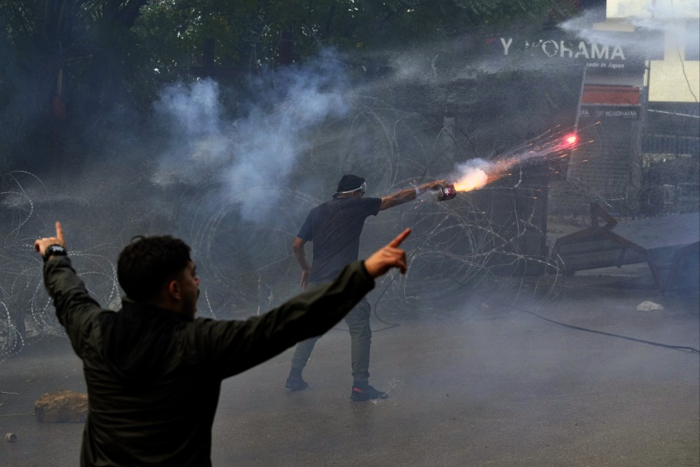 A protester launches fireworks at riot police near the US embassy in Beirut, Lebanon, during a demonstration on Wednesday. Photo: AP