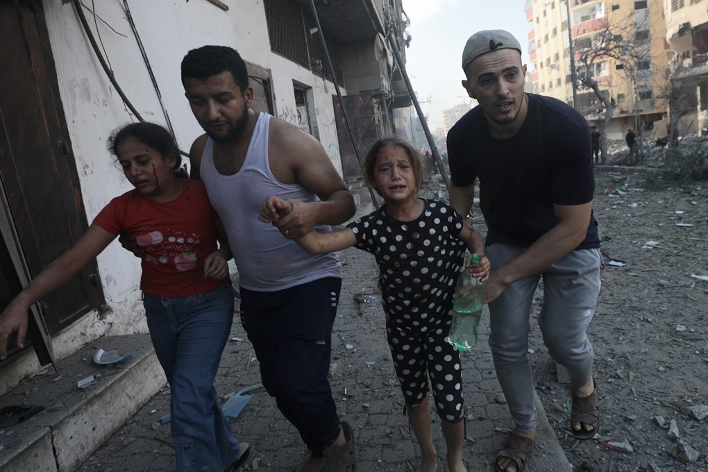 Two men help two wounded girls following an Israeli airstrike in Gaza. Photo: EPA-EFE