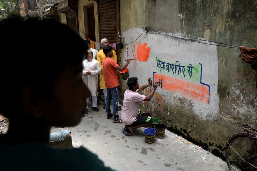 Workers from India’s ruling Bharatiya Janata Party (BJP) paint slogans and party symbols on a wall in Kolkata as part of an outreach programme. Photo: Reuters