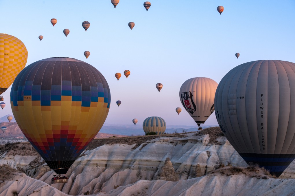 Hot air balloons fly over Cappadocia, Turkey, a popular tourist destination known for its volcanic landscape and cave cities. Places on balloon flights are now bookable through Uber. Photo: Xinhua