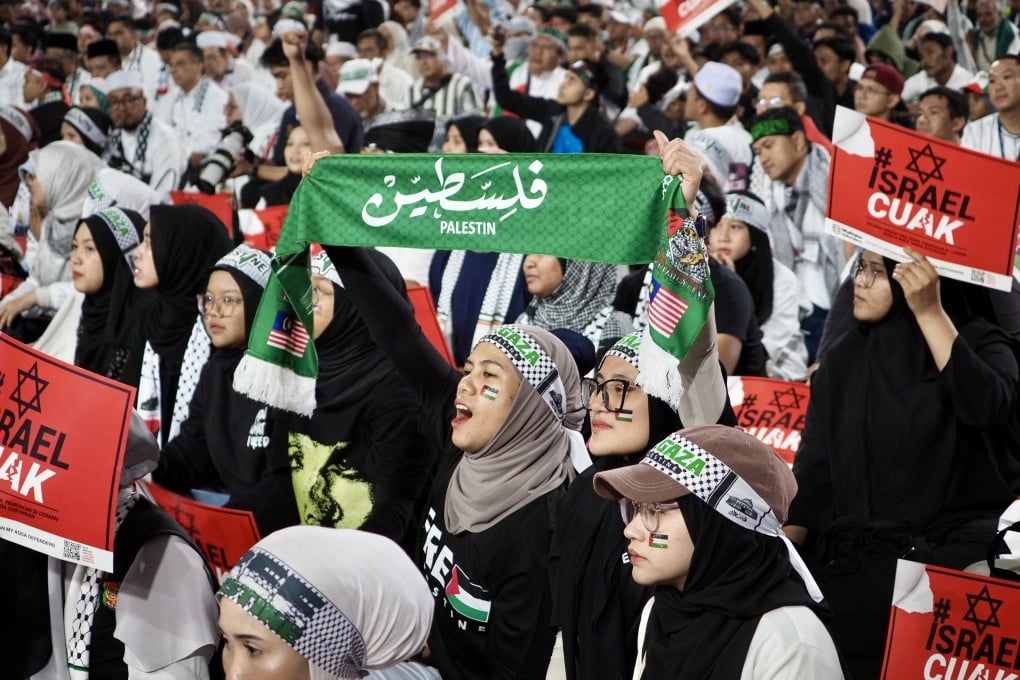 Malaysian Muslims hold up signs and slogans at a pro-Palestine rally in a Kuala Lumpur stadium on Tuesday: Photo: Hadi Azmi