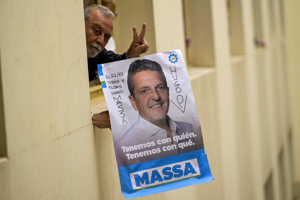 A worker holds a poster of Argentine economy minister Sergio Massa, in Buenos Aires on October 23, a day after Massa won the first round of the presidential election. Massa and anti-establishment outsider Javier Milei are set for a run-off presidential poll next month in a contest between two wildly different versions of the country. Photo: AFP