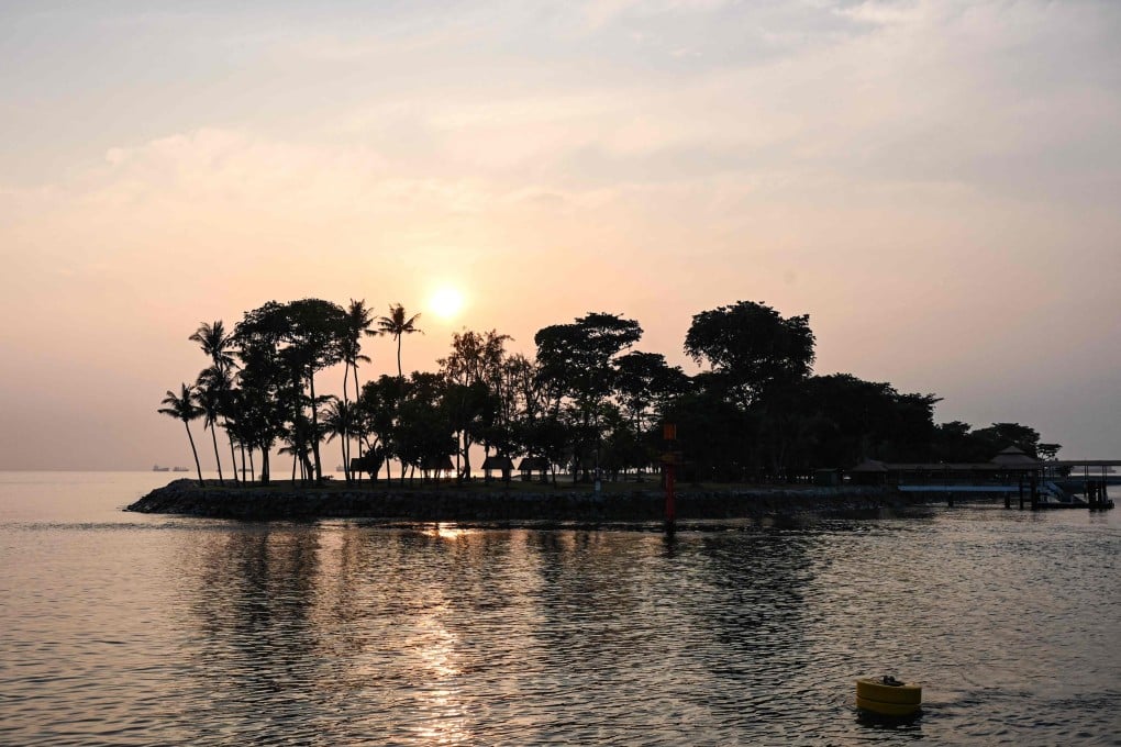 The sun rises behind Singapore’s Kusu Island and the Da Bo Gong temple during the annual pilgrimage on the ninth month of the Lunar calendar. Photo: AFP