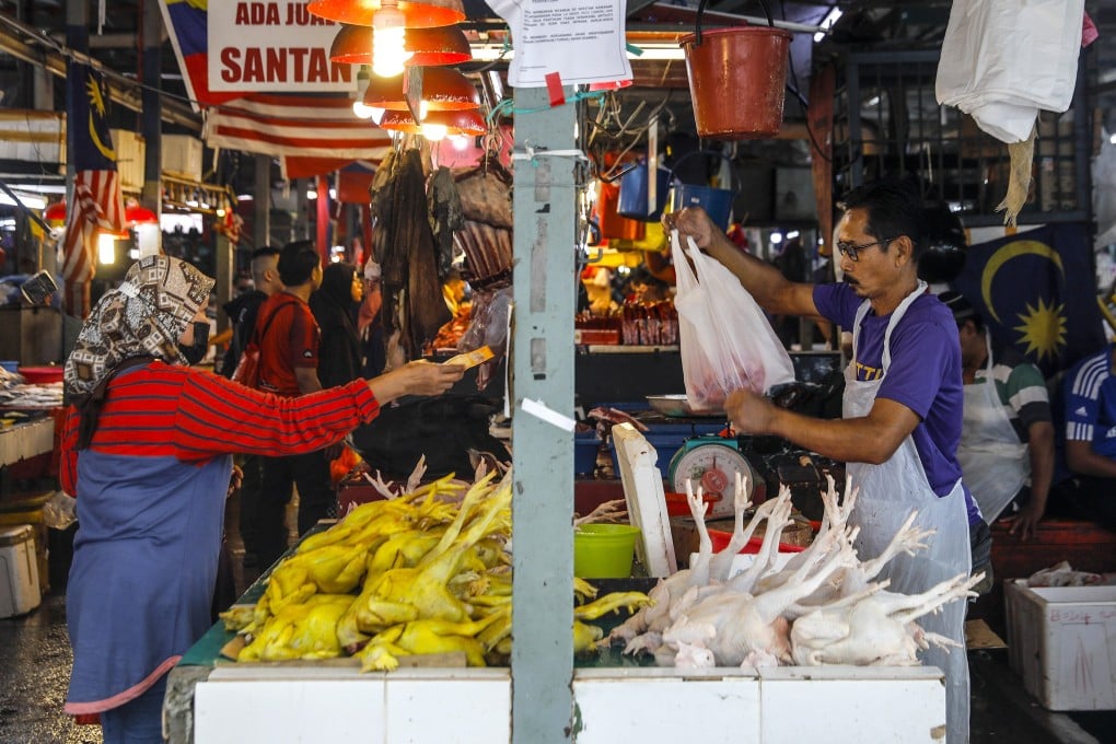 A customer buys a chicken at a wet market in Kuala Lumpur. Photo: EPA-EFE