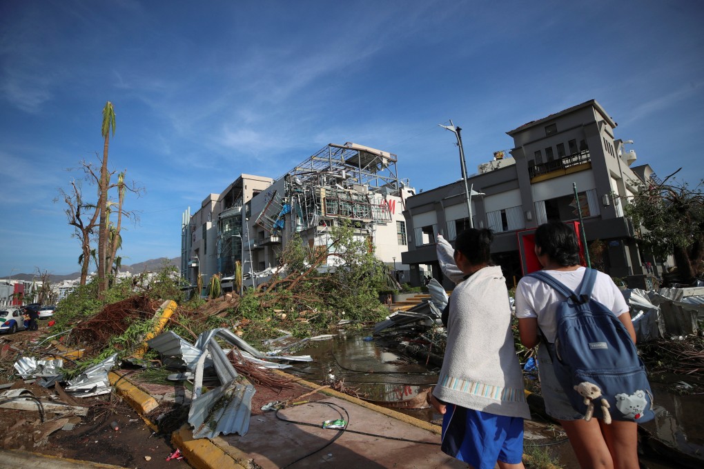 People look at some of the damage caused by Hurricane Otis in Acapulco, Mexico, on Thursday. Photo: Reuters