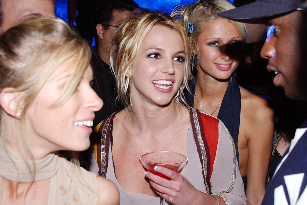 Britney Spears (centre) at a party in Los Angeles in October 2002 with Paris Hilton and Sean “P Diddy” Combs and other guests. The singer’s new book, “The Woman in Me” talks about everything from dating Justin Timberlake to her abortion and conservatorship. Photo: Getty Images