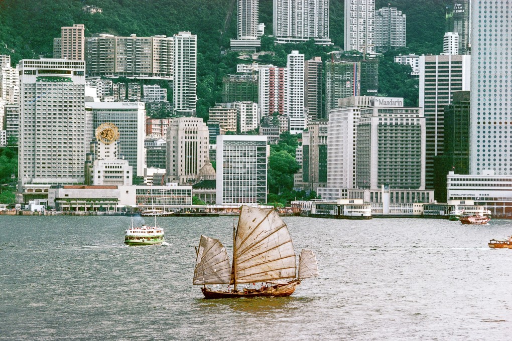 A lone junk plies Victoria Harbour in 1982,  by which time the fleets of junks that once plied its waters were a thing of the past. The Hong Kong Tourism Board adopted a junk as a symbol of the city with great success, but it long ago ceased representing reality.