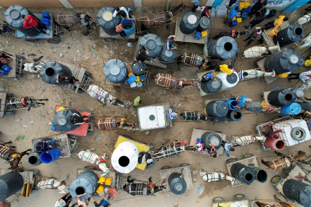 Palestinians with animal-drawn carts collect water from a water desalination plant, amid water shortages, as the conflict between Israel and Hamas continues in the Gaza Strip on October 27. Photo: Reuters