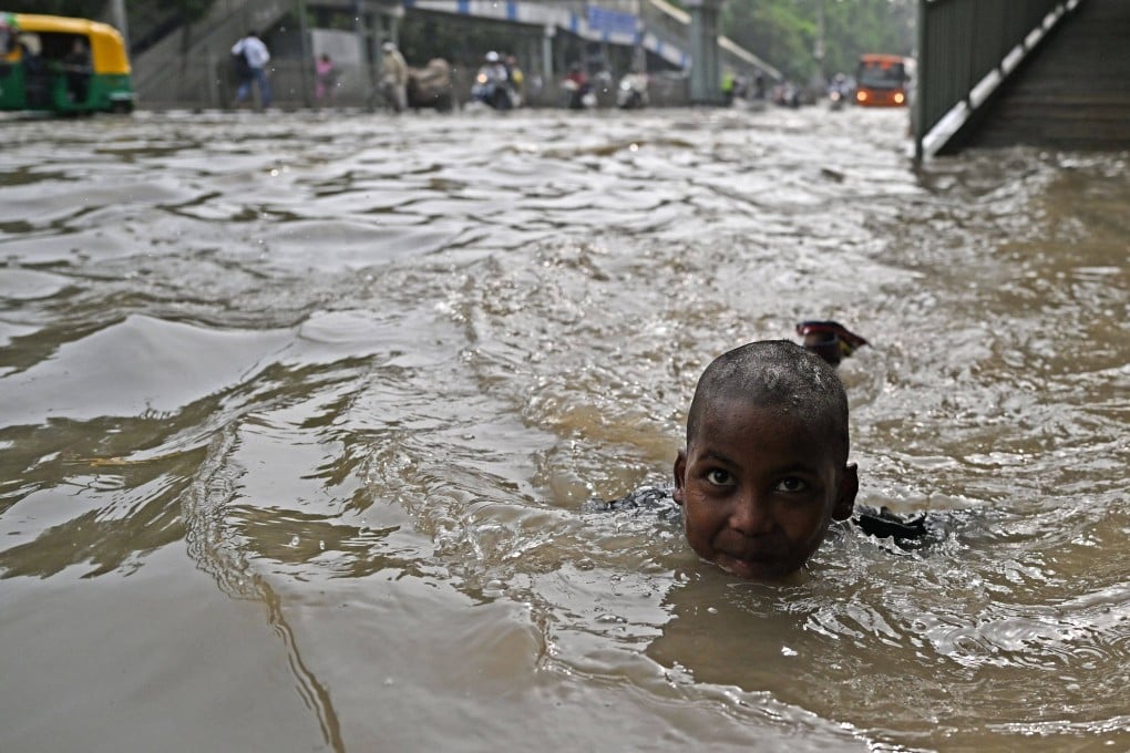 A child swims through a flooded street after Yamuna River overflowed due to monsoon rains in New Delhi. From record-breaking heatwaves to floods and landslides, the Hindu Kush Himalaya region has witnessed some of the worst climate-related disasters in recent memory. Photo: AFP