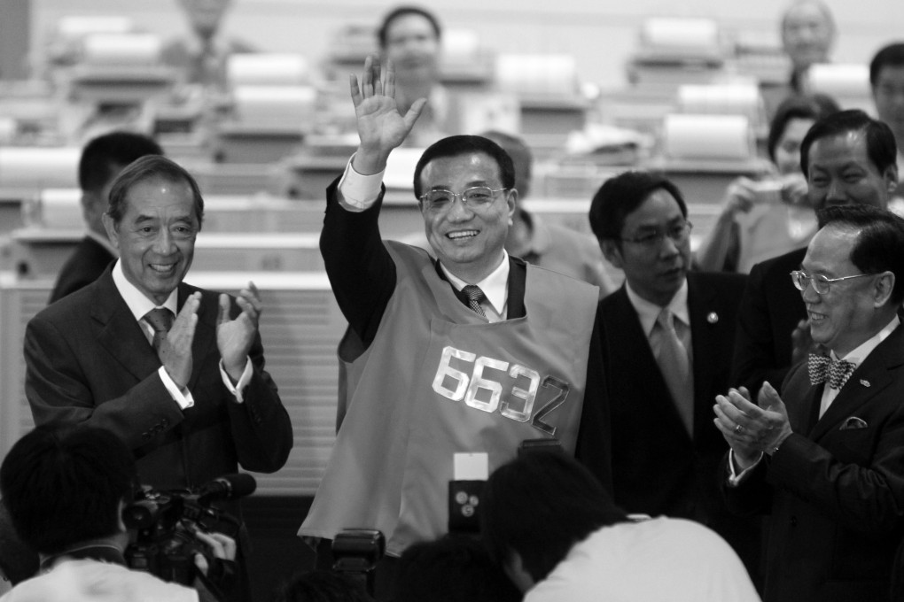 Li Keqiang (centre) dons a trader’s visit during a visit to Hong Kong’s stock exchange in August 2011. Photo: David Wong