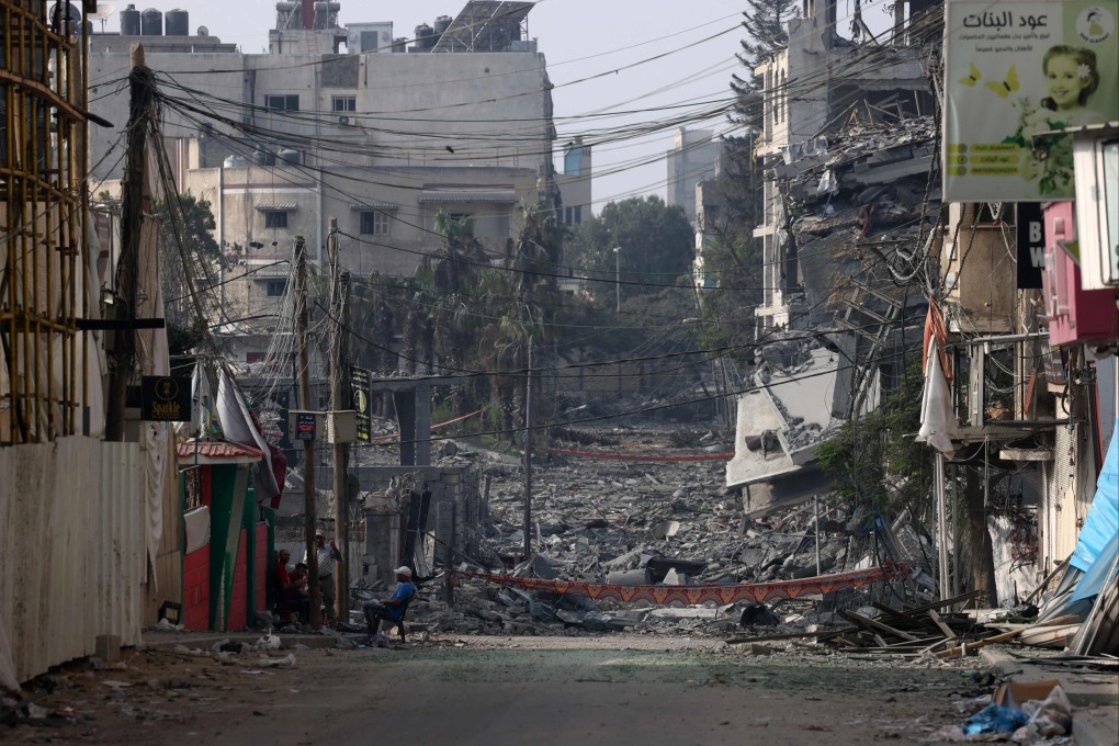 A man sits in front of buildings destroyed by Israeli strikes in Gaza. Photo: AFP