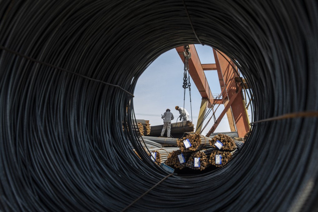 Workers prepare to lift a bundle of steel reinforcing bar with a gantry crane at a metal stock yard in Shanghai. The construction industry, which consumes massive amounts of steel and aluminium, still gets most of the financing from Beijing despite a slowing economy. Photo: Bloomberg
